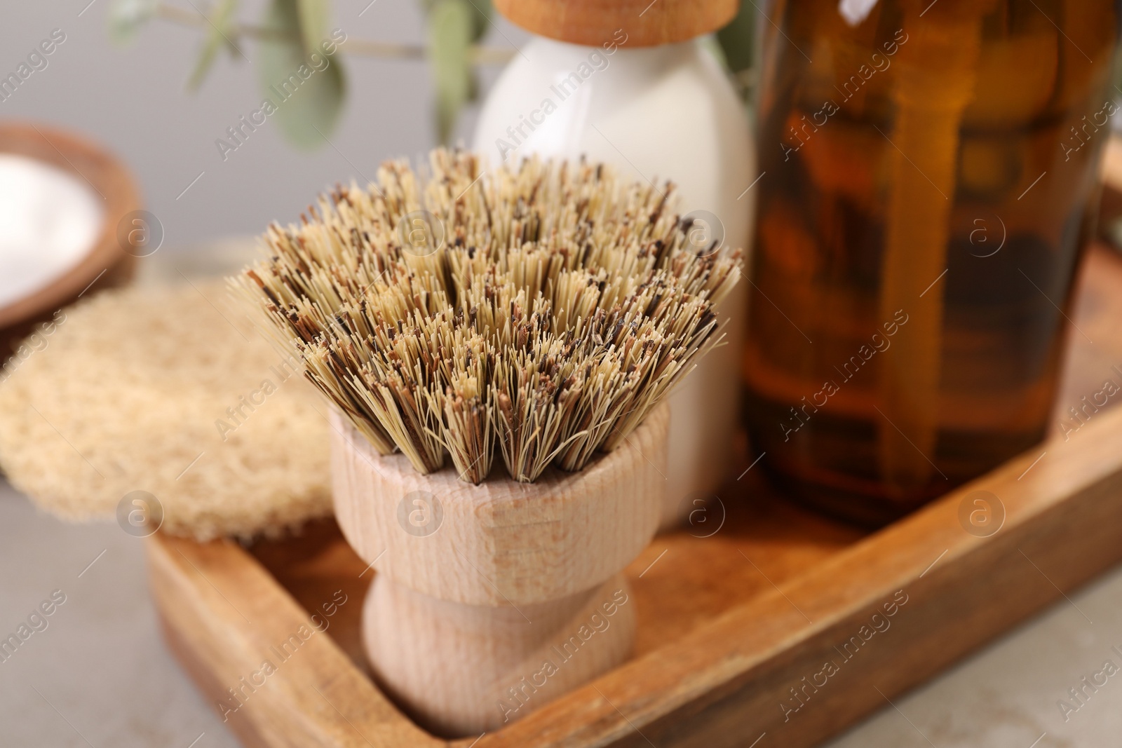 Photo of Cleaning brush, bottles and sponge on table, closeup