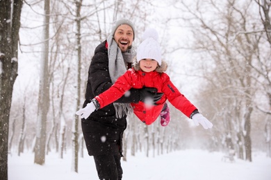 Photo of Father with his child having fun outside on winter day. Christmas vacation