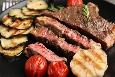 Photo of Delicious grilled beef steak with vegetables and spices on plate, closeup