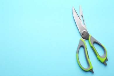 Kitchen scissors on color background, top view. Space for text