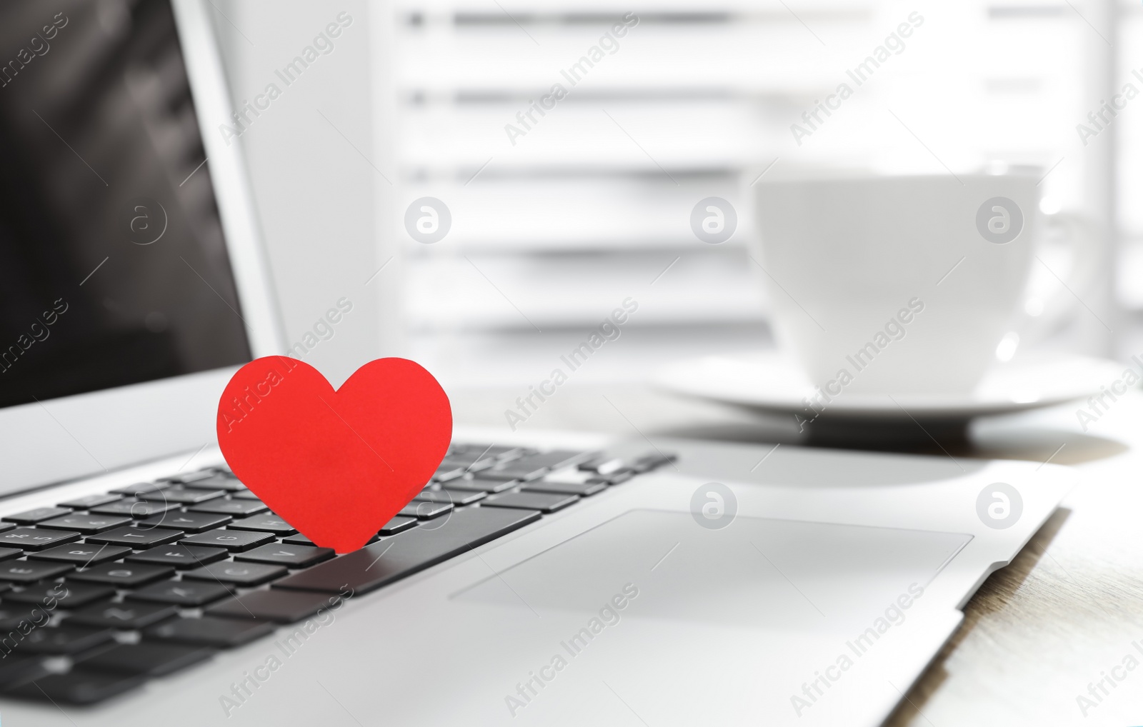 Photo of Red heart on laptop in office, space for text. Valentine's day celebration