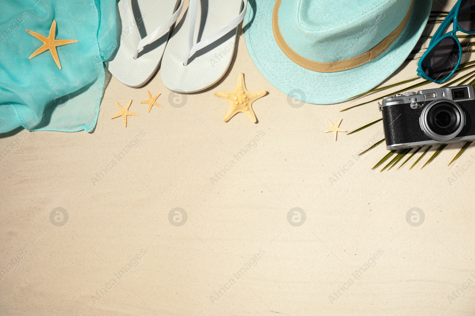 Photo of Composition with beach accessories and space for text on sand, flat lay