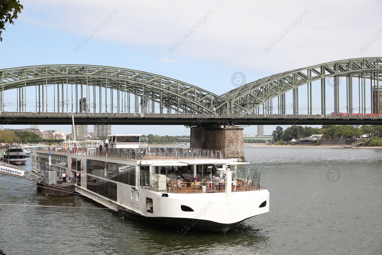 Photo of Cologne, Germany - August 28, 2022: Picturesque view of a modern bridge over river and ferry boat