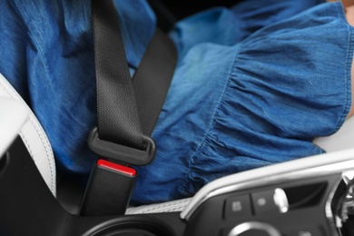Photo of Female driver with fastened safety belt in car, closeup