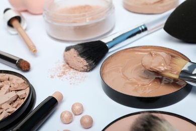 Photo of Composition with skin foundation, powder and beauty accessories on white background