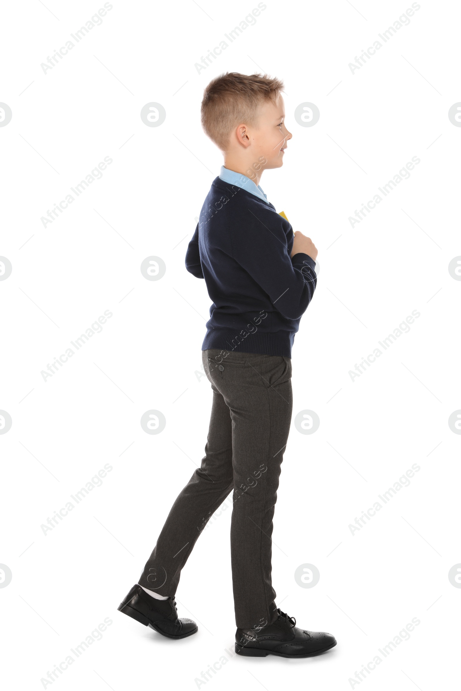 Photo of Full length portrait of cute boy in school uniform on white background
