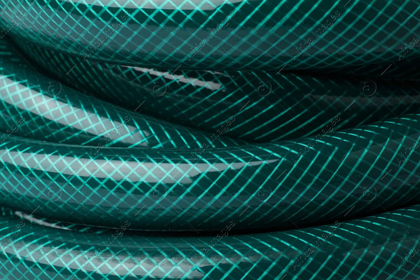 Photo of Green rubber watering hose as background, closeup