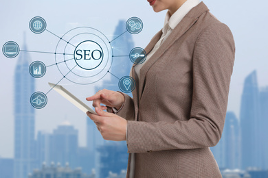 Image of SEO directions with icons of keyword research, customization and others. Woman using tablet 