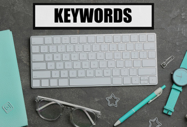 Image of Flat lay composition with keyboard and text KEYWORDS on grey background