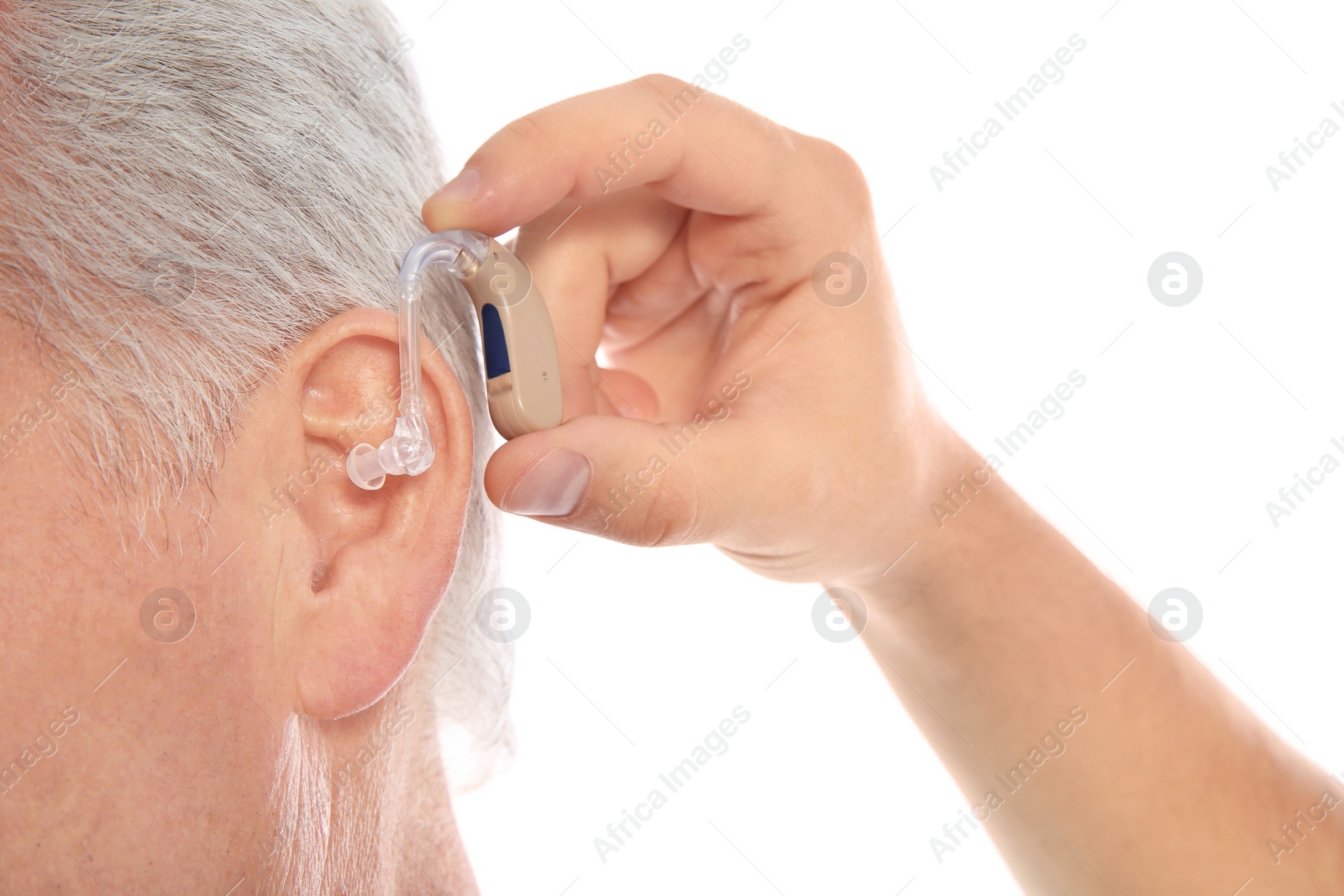 Photo of Young man putting hearing aid in father's ear on white background, closeup