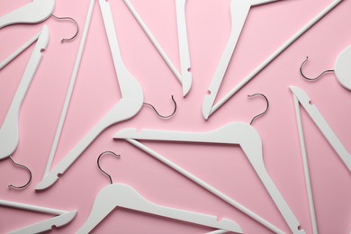 White hangers on pink background, flat lay