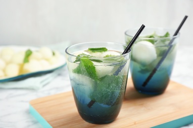 Glasses with tasty melon ball drinks on table