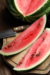 Photo of Yummy cut watermelon slices on wooden table