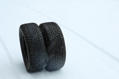 Photo of New winter tires on fresh snow. Space for text