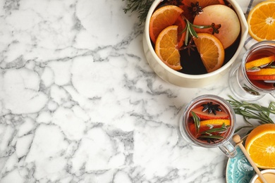 Photo of Tasty mulled wine with spices on white marble table, flat lay. Space for text