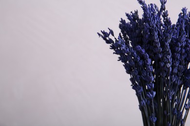 Photo of Bouquet of beautiful preserved lavender flowers on beige background, closeup. Space for text