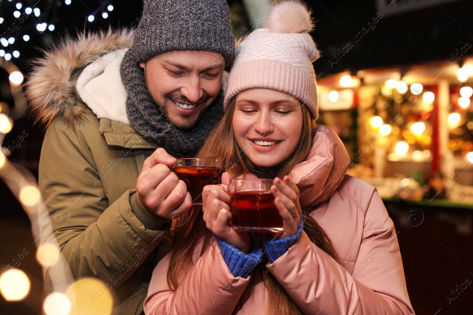 Photo of Happy couple with mulled wine at winter fair