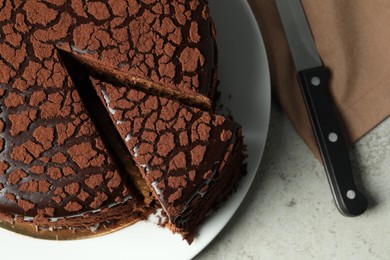Photo of Delicious chocolate truffle cake and knife on grey table, top view