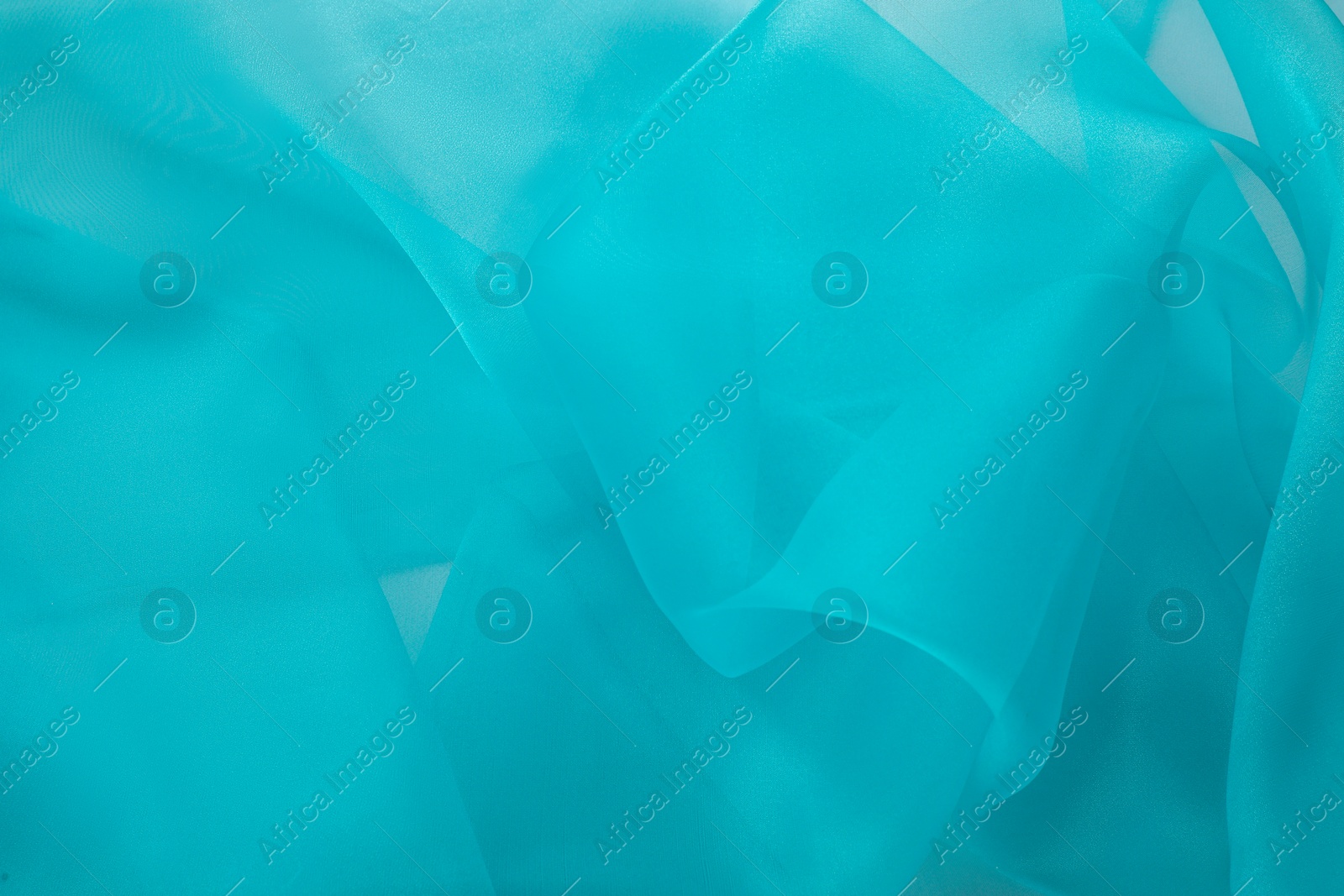 Photo of Beautiful turquoise tulle fabric as background, closeup