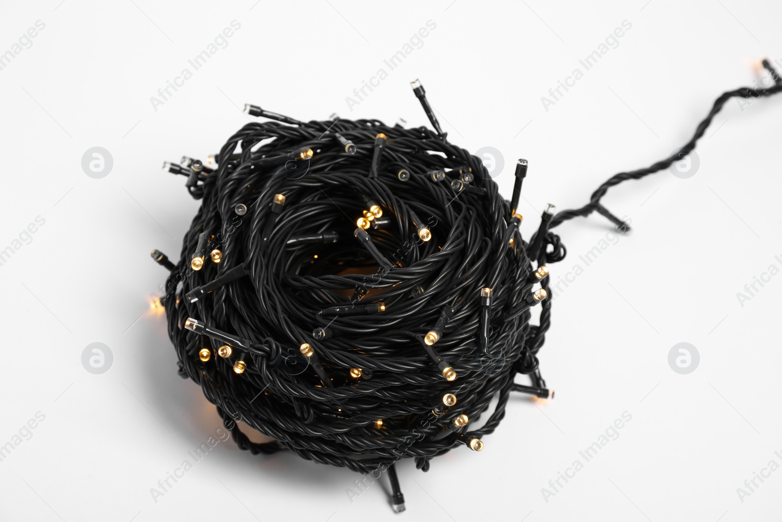 Photo of Beautiful Christmas lights on white background, closeup