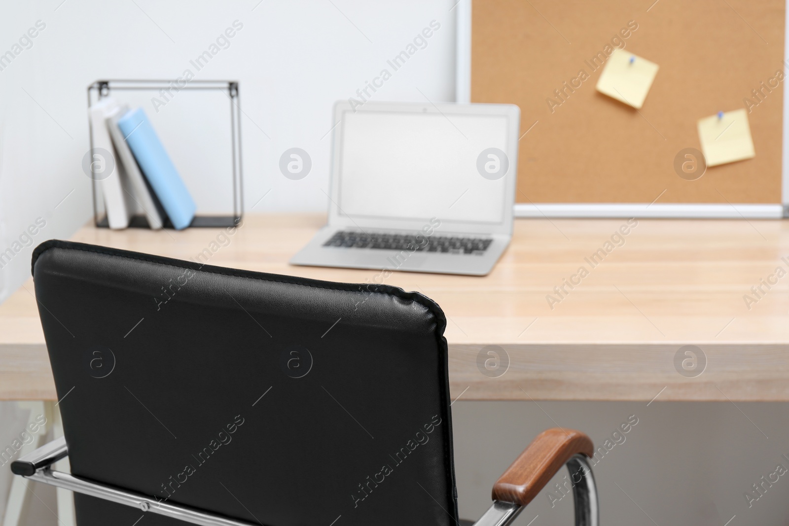 Photo of Stylish workplace interior with office chair and wooden table