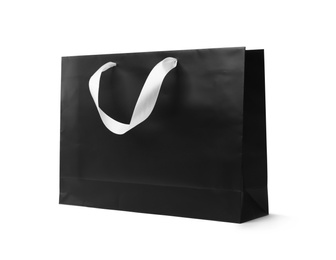 Photo of Paper shopping bag with ribbon handles on white background. Mockup for design