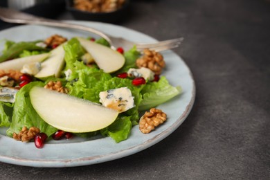 Photo of Delicious pear salad on dark textured table, closeup