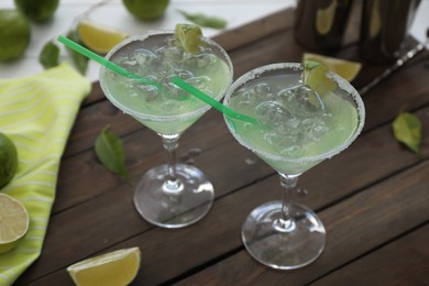 Photo of Delicious Margarita cocktail in glasses on wooden table, closeup