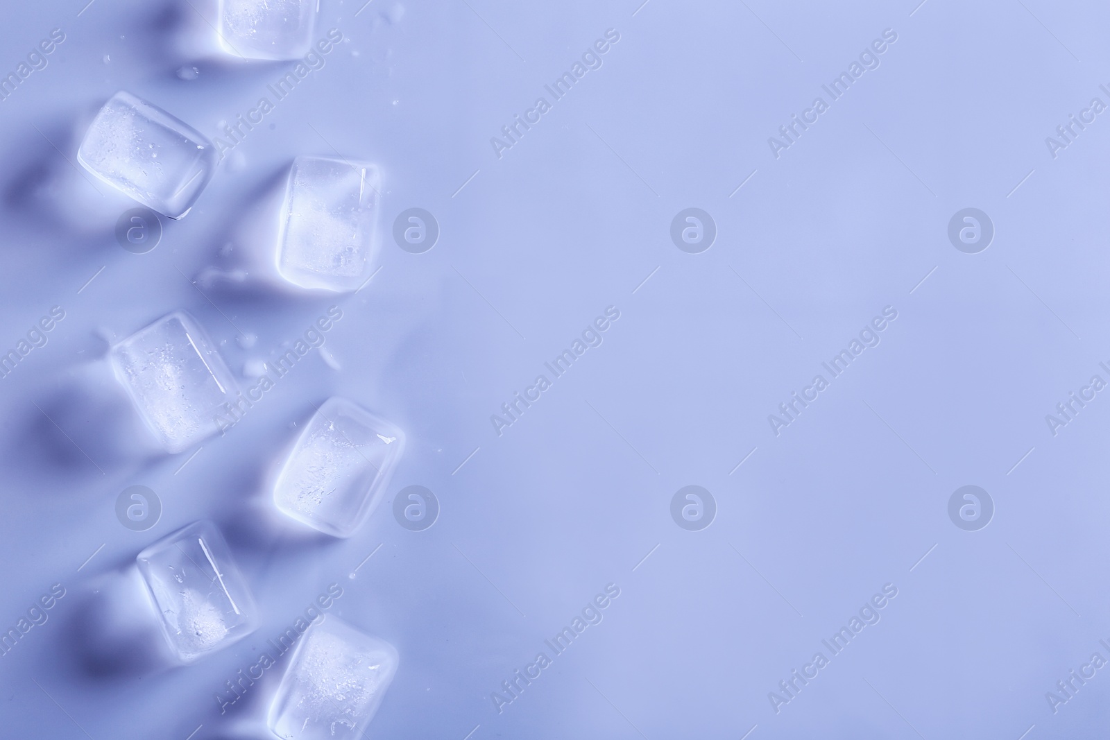 Photo of Ice cubes on color background, top view. Space for text