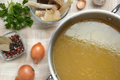 Photo of Delicious homemade bone broth and ingredients on table, flat lay