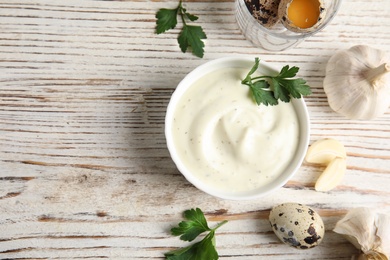 Photo of Flat lay composition with garlic sauce on wooden background. Space for text