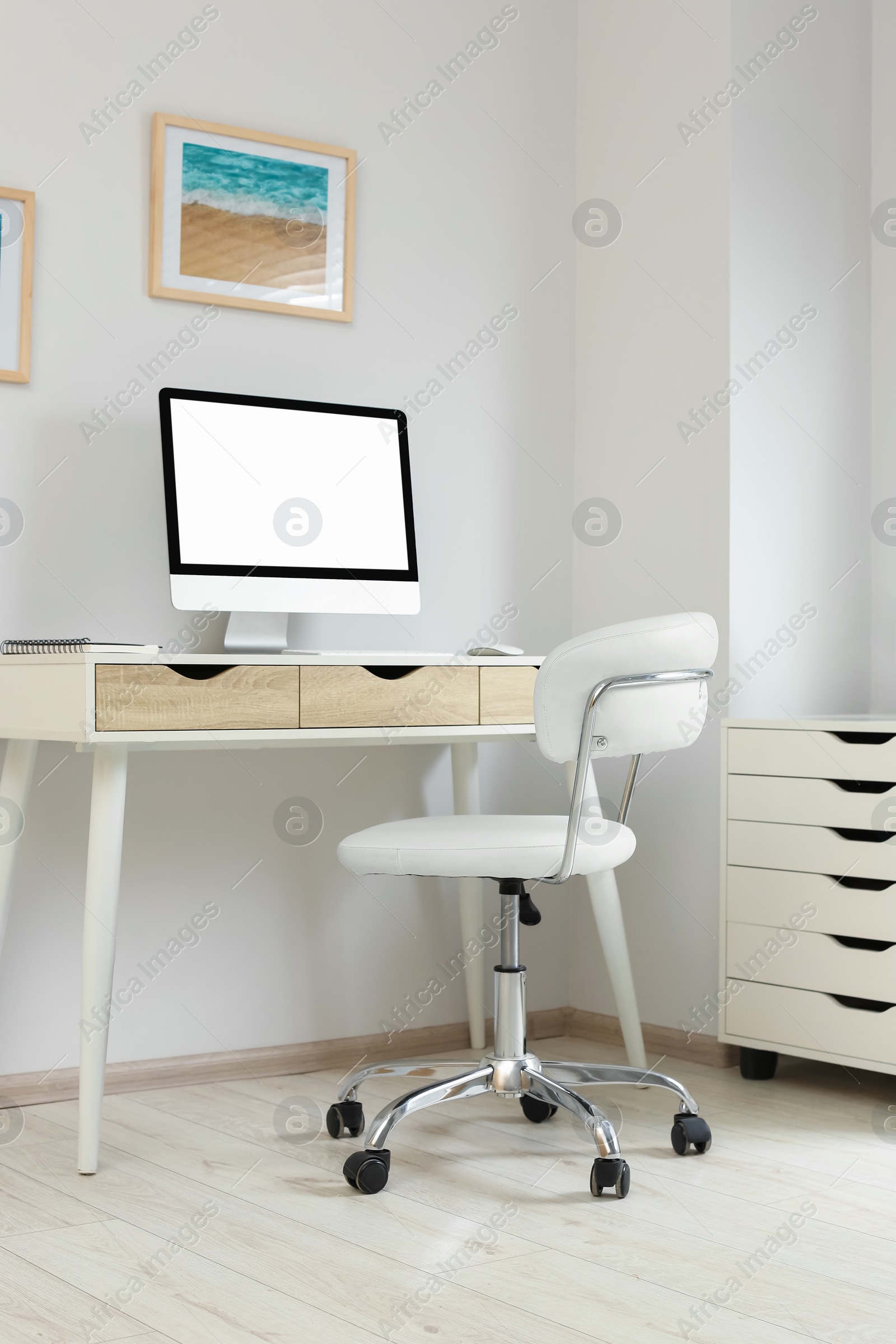Photo of Stylish office interior with comfortable chair, desk and computer