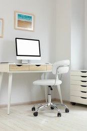 Photo of Stylish office interior with comfortable chair, desk and computer