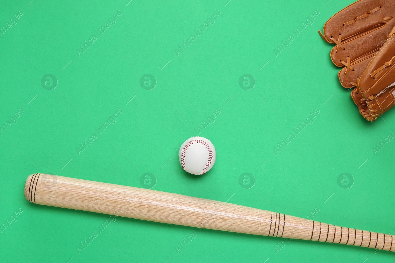 Photo of Baseball glove, bat and ball on green background, flat lay. Space for text