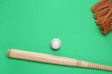 Photo of Baseball glove, bat and ball on green background, flat lay. Space for text