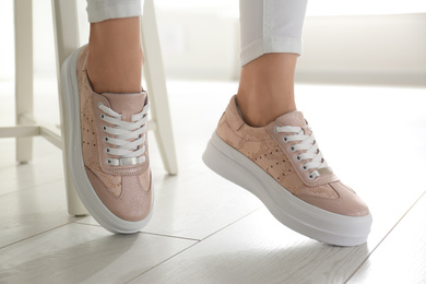 Photo of Woman wearing comfortable stylish shoes indoors, closeup