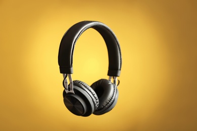 Photo of Stylish headphones with pads on color background