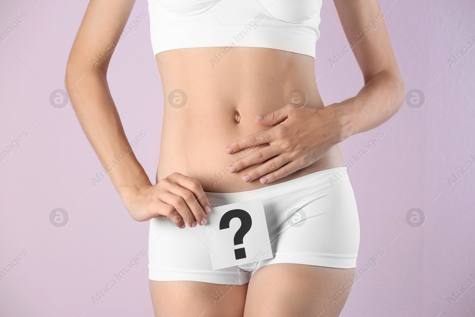 Photo of Young woman holding card with question mark on color background. Gynecology concept