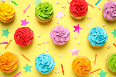 Colorful birthday cupcakes on yellow background, flat lay