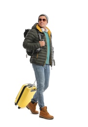Photo of Man with suitcase and backpack walking on white background. Winter travel