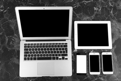 Photo of Devices with blank screens on marble background, top view. Mock up for design