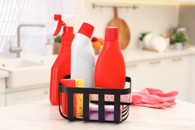 Photo of Different cleaning supplies in basket on table