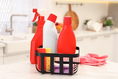 Different cleaning supplies in basket on table