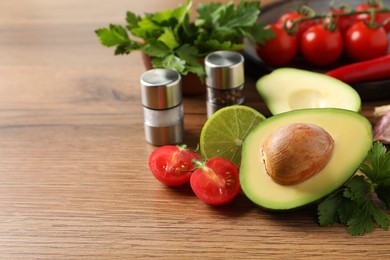 Photo of Fresh guacamole ingredients on wooden table. Space for text