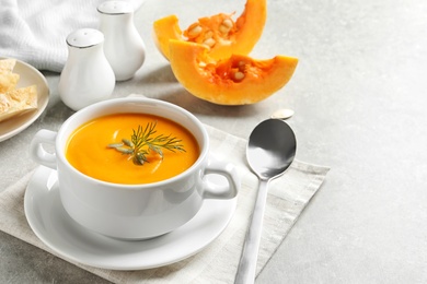 Photo of Delicious pumpkin cream soup in bowl on light table