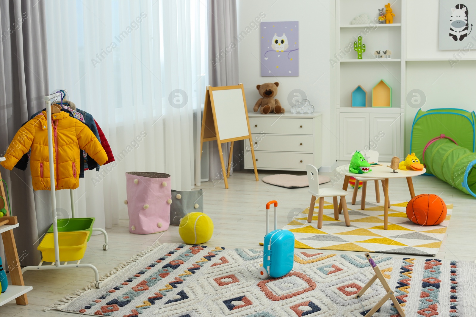 Photo of Child`s playroom with different toys and modern furniture. Stylish kindergarten interior