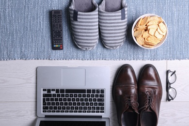 Flat lay composition with business items and home accessories on wooden floor with blue rug. Concept of balance between work and life