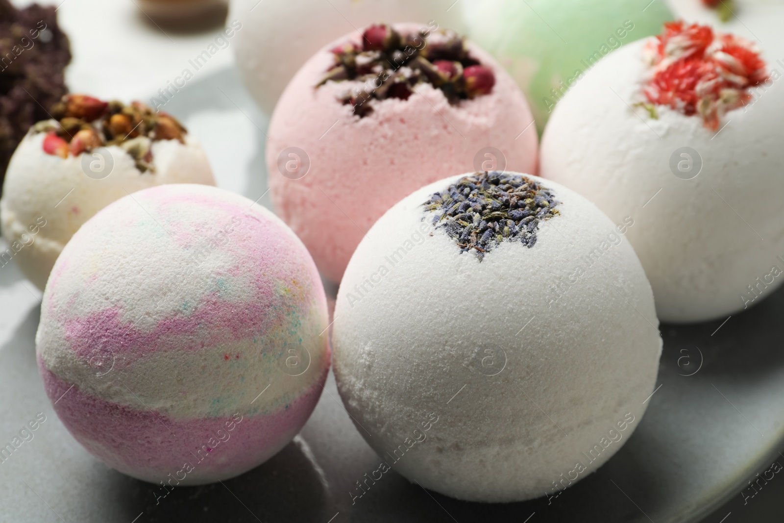 Photo of Plate with different bath bombs on table, closeup