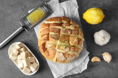 Freshly baked bread with tofu cheese served on grey table, flat lay