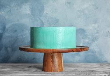 Fresh delicious birthday cake on stand against color background